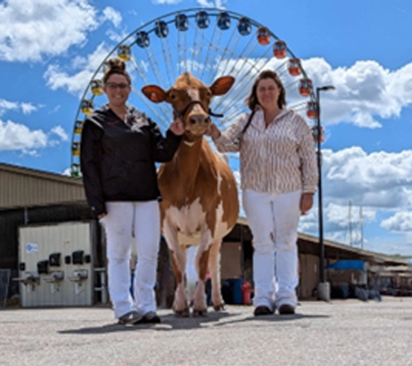 breanna & tammy under ferris wheel with cow