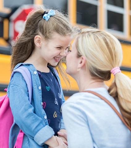 Mother and daughter at school bus