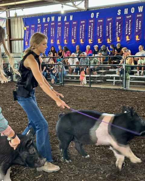 Jayden Rather at 2024 Waukesha County Fair with a black and white pig on a lead